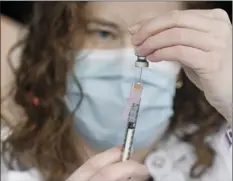  ?? AP photo ?? System Pharmacy Clinical Manager Colleen Teevan at Hartford HealthCare prepares the Pfizer-BioNTech vaccine for COVID-19 to give to a front line worker outside of Hartford Hospital on Monday in Hartford, Conn.