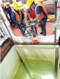  ??  ?? ARCTIC OCEAN, at sea: Members of the Canadian Coast Guard assigned to the CCGS Amundsen, assist scientists to deploy a pump through the hull of the ship.