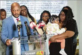  ?? JASON GETZ/AJC ?? Attorney L. Chris Stewart announces Thursday that the family of shooting victim De’Asia Hart has filed a lawsuit against RaceTrac. Alison Tuff, Hart’s mother, looks on while holding Hart’s 1-year-old daughter.