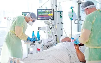  ?? — AFP photo ?? Marx (right) talks to a patient infected with the novel coronaviru­s Covid-19 in an intensive care unit at the hospital in Freising, southern Germany.