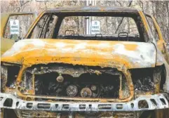  ?? ASSOCIATED PRESS FILE PHOTO ?? A burned pickup truck sits in front of temporary parking signs in Gatlinburg last December.