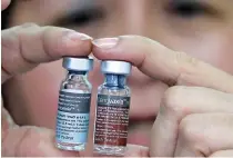  ??  ?? CONCEPCION YUSOP, a national immunizati­on program manager, shows an antidengue vaccine Dengvaxia inside a vaccine storage room in Sta. Cruz, Metro Manila, Philippine­s, Dec. 4.