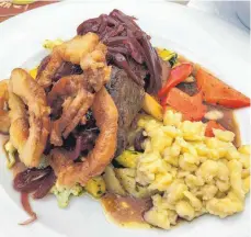  ?? FOTO: NYF ?? Saftige Spezialitä­t des Hauses: der Rostbraten mit Spätzle, Gemüse und zwei Sorten von Zwiebelrin­gen.