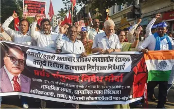  ?? — PTI ?? Dalit activist and supporters hold placards and raise slogans during a protest march against the alleged dilution of Scheduled Castes/ Scheduled Tribes Act in Mumbai in April