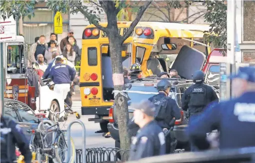  ?? BEBETO MATTHEWS/ AP ?? Authoritie­s respond near a damaged school bus Tuesday after a truck speeded onto a busy bicycle path in Manhattan.