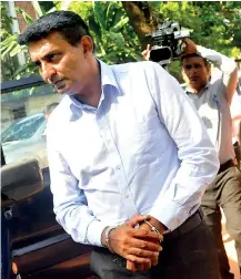  ??  ?? SriLankan Airline's former CEO Kapila Chandrasen­a (right) and his wife Priyanka Wijenayake being led to a prisons vehicle after the Fort Magistrate ordered that they be remanded.