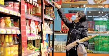  ?? (AFP) ?? A woman wearing a protective mask shops in Beijing on February 1