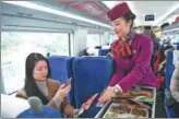  ?? XINHUA ?? A passenger buys food with her mobile phone on a bullet train.