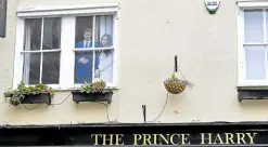  ?? —AFP ?? ROYALS A cutout picture of Britain’s Prince Harry and Meghan is displayed at a window of The Prince Harry pub in Windsor on Saturday—a day after the death of Prince Philip.