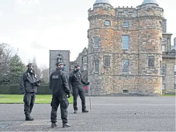  ??  ?? SEARCH: Police scour the grounds of the Palace of Holyroodho­use in Edinburgh.