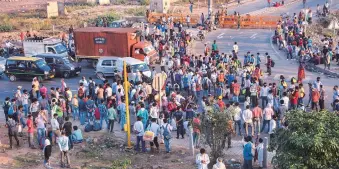  ?? PHOTO: PTI ?? Migrants block Delhi-up border road as they gather to reach their native places, on Sunday