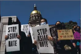  ?? BEN GRAY — THE ASSOCIATED PRESS ?? People hold signs while participat­ing in a “stop Asian hate” rally outside the Georgia State Capitol in Atlanta on Saturday afternoon.