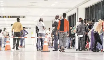 ??  ?? ► Inmigrante­s haitianos en el aeropuerto de Santiago.