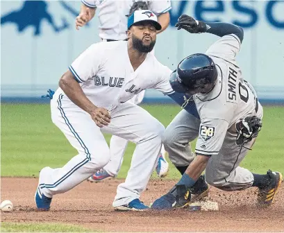  ?? FRED THORNHILL THE CANADIAN PRESS ?? Tampa Bay’s Mallex Smith steals second base in the first inning when Jays call-up Richard Urena can’t hang on to the ball.
