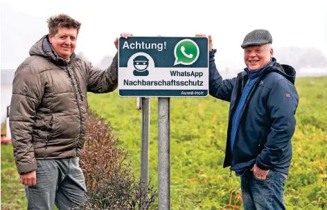  ?? RP-FOTO: SPÜTZ ?? Swen Feegers (l.) und Matthias Leuken an einem der Hinweissch­ilder auf die dörfliche Whatsapp-Gruppe.