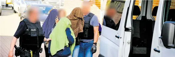  ?? DPA-BILD: SPATA ?? Schlag gegen die Organisier­te Kriminalit­ät: Polizisten führen drei Frauen aus einem Haus in Hannover (Stadtteil Anderten) ab.