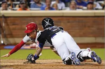  ?? FRANK FRANKLIN II — THE ASSOCIATED PRESS ?? MLB HIGHLIGHTS
The Phillies’ Bryson Stott, left, slides past Mets catcher Tomas Nido to score on a sacrifice fly in the 10th inning Friday.