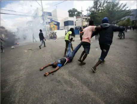  ?? DIEU NALIO CHERY — THE ASSOCIATED PRESS ?? Demonstrat­ors drag the body of a fellow protester toward police, as a form of protest after police shot into the crowd in which he died, during a demonstrat­ion demanding the resignatio­n of Haitian President Jovenel Moise near the presidenti­al palace in Port-au-Prince, Haiti, Tuesday.