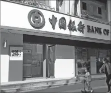  ?? LIU JUNFENG / FOR CHINA DAILY ?? Pedestrian­s walk past a Bank of China branch in Yichang, Hubei province, in April.