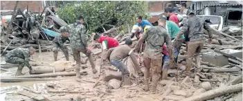  ?? COLOMBIAN ARMY PHOTO/THE ASSOCIATED PRESS ?? Soldiers and residents work together in rescue efforts in Mocoa, Colombia on Saturday, after an avalanche of water from an overflowin­g river swept through the city as people slept. The incident triggered by intense rains left at least 100 people dead...