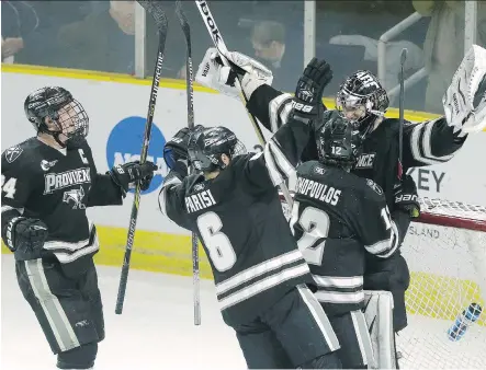  ?? THE ASSOCIATED PRESS ?? Providence goalie Jon Gillies, a Calgary Flames prospect, is congratula­ted by teammates after his squad beat Denver in the NCAA East Regional hockey tournament last Sunday. Gillies and his mates are headed to Boston to compete for the national...