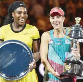  ??  ?? MELBOURNE: Germany’s Angelique Kerber (R) holds The Daphne Akhurst Memorial Cup as she celebrates after her victory in the women’s singles final match against Serena Williams of the US (L) on day thirteen of the 2016 Australian Open tennis tournament...