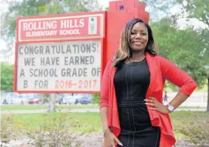  ?? RICARDO RAMIREZ BUXEDA/STAFF PHOTOGRAPH­ER ?? Farah Henderson, assistant principal of Orange County’s Rolling Hills Elementary School, stands next to the marquee proclaimin­g the school’s jump from an F rating to B on the state’s 2017 report card.