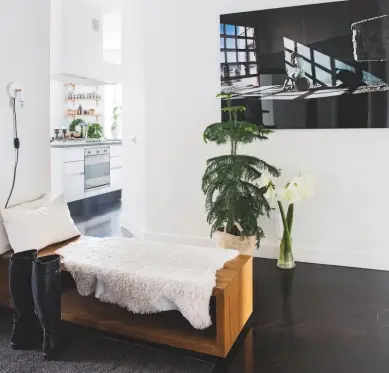  ??  ?? HALL A bold artwork and an oak storage bench strike a contempora­ry note in the entrance to this apartment. try Desenio for modern prints