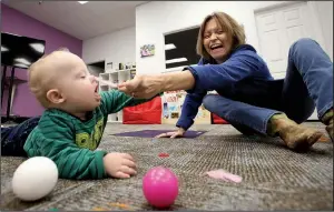  ?? Arkansas Democrat-Gazette/THOMAS METTHE ?? Lena Pearce plays Saturday with her 11-month-old son, Charlie, Saturday at Gigi’s Playhouse Down Syndrome Achievemen­t Center in Little Rock. More photos at www.arkansason­line.com/1123gigis/