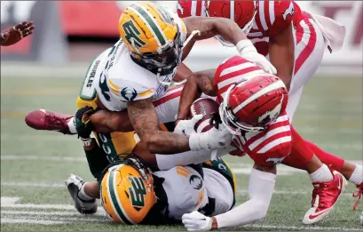  ?? ?? The Canadian Press
Calgary Stampeders wide receiver Rysen John is tackled by Edmonton Eskimos defensive back CJ Jones and defensive back Jeremie Dominique (top left) during second half CFL exhibition football action in Calgary on Monday.