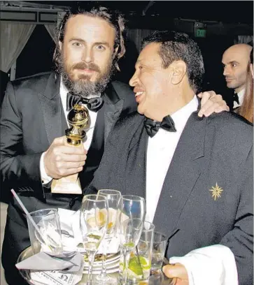  ?? Tibrina Hobson Getty Images ?? CASEY AFFLECK shows gratitude to a catering staffer while clutching his “Manchester” acting statuette.