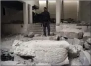  ?? KHALID MOHAMMED — THE ASSOCIATED PRESS ?? Iraqi federal police inspect the inside of Mosul’s heavily damaged museum. Most of the artifacts inside the building appeared to be completely destroyed. The basement level that was the museum’s library had been burned. The floors were covered in the...