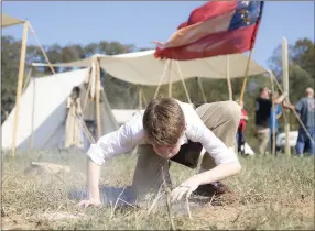  ?? NWA Democrat-Gazette photograph­s by Charlie Kaijo ?? Gavin Crawford, 11, of Joplin, Mo., blew on a fire Friday at a field north of Pea Ridge along the Missouri border in Pea Ridge. Members of the trans Mississipp­i Brigade set up camp for visitors to see life as it was in the 1860s in a battle camp.