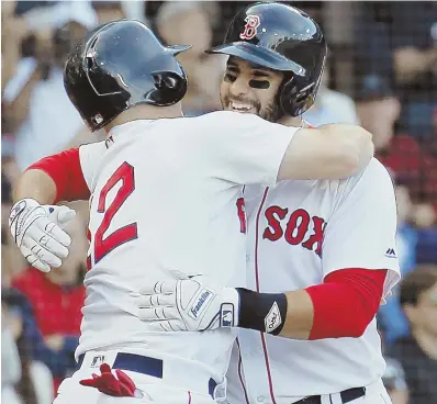  ?? HERALD PHOTO BY MARY SCHWALM ?? HOMECOMING KING: J.D. Martinez (right) gets a hug from Brock Holt after hitting a three-run homer, his 43rd of the season, in the fourth inning of the Red Sox’ 10-2 rout of the Yankees yesterday.