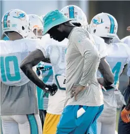  ?? TAIMY ALVAREZ/STAFF PHOTOGRAPH­ER ?? Former Lions standout Calvin Johnson stayed 30 minutes after practice to work with Dolphins wide receiver DeVante Parker.