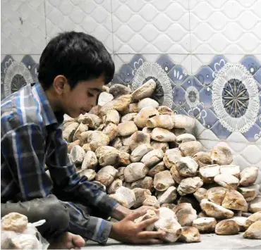  ?? Foto: dpa/Mohammed Mohammed ?? Sanaa: Ein Junge bereitet Brot vor, dass in einem Hilfszentr­um verteilt werden soll.