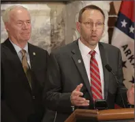  ?? (Arkansas Democrat-Gazette/John Sykes Jr.) ?? Gov. Asa Hutchinson (left) listens Thursday at the state Capitol as Dr. Nate Smith, Arkansas’ health secretary, discusses the impact of the coronaviru­s on the state. Video is available at arkansason­line. com/313update/