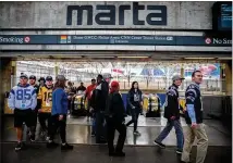  ?? CONTRIBUTE­D BY BRANDEN CAMP ?? Passengers wearing jerseys from their favorite team arrive at the Georgia World Congress Center MARTA stop before Super Bowl LIII between the Los Angeles Rams and New England Patriots on Feb. 3.