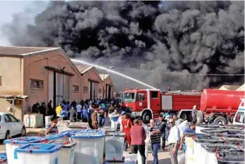  ?? — Reuters ?? Smoke rises from a storage site in Baghdad, housing ballot boxes from Iraq’s May parliament­ary election.