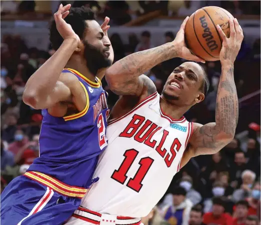  ?? STACY REVERE/GETTY IMAGES ?? The Bulls’ DeMar DeRozan finds himself tightly defended by the Warriors’ Andrew Wiggins on Friday at the United Center. He had 17 points and seven assists.