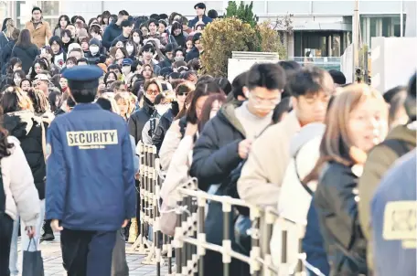  ?? — AFP photo ?? Fans queue up to buy merchandis­e in front of the Tokyo Dome a few hours ahead of the first leg of the Asia-Pacific tour by US superstar performer Taylor Swift in Tokyo.