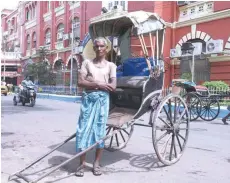  ?? — AFP ?? Mohammad Ashgar, 65, a rickshaw puller, poses for a photograph next to his rickshaw in Kolkata.