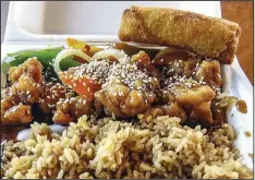  ?? Arkansas Democrat-Gazette/ROSEMARY BOGGS ?? The crisp sesame chicken at Asia Express in Cabot, served with rice and an egg roll, comes coated in a brown sauce, mixed with vegetables and sprinkled with sesame seeds.