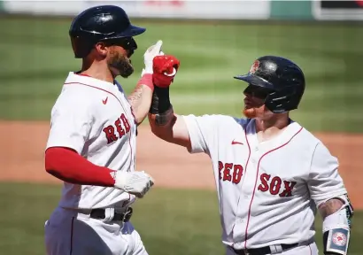  ?? NAncy lAnE / HERAld sTAFF ?? RISKY BUSINESS: Red Sox outfielder Kevin Pillar, left, bangs forearms with Christian Vazquez after a home run against the Orioles on Sunday. The team is looking to avoid contact at all costs after the Miami Marlins virus outbreak.