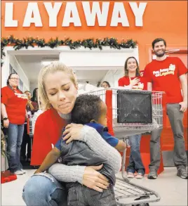  ?? Benjamin Hager ?? Las Vegas Review-journal @benjaminhp­hoto Reality TV star Kendra Wilkinson hugs Jaiden Lewis, 1, during an event for the nonprofit Pay Away the Layaway at a Kmart on Tuesday.