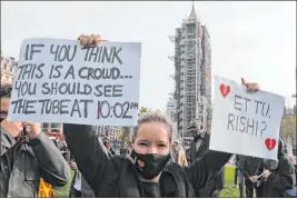  ?? Frank Augstein The Associated Press ?? Hospitalit­y workers protest Monday in London against tougher coronaviru­s restrictio­ns and the amount of government financial support given to their industry.