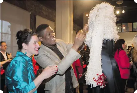  ?? PHOTOS: GRAHAM HUGHES/ THE GAZETTE ?? Helmer Joseph makes an adjustment to one of his creations alongside Suzanne Chabot, director of the Musée du costume et du textile du Québec.