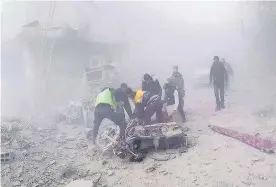  ??  ?? > Civil defence workers carry an injured man after government airstrikes hit Douma, near Damascus, Syria, yesterday