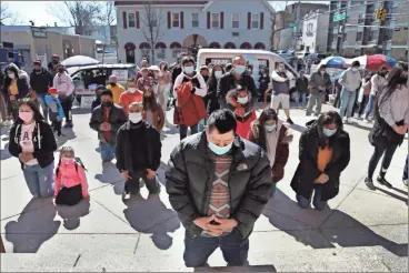  ?? Ap-jessie Wardarski ?? Parishione­rs kneel during a Mass relayed via loudspeake­r outside Our Lady of Sorrows in the Queens borough of New York on March 21. The Rev. Manuel Rodriguez says more than 100 parishione­rs of the Roman Catholic church have died from the coronaviru­s.