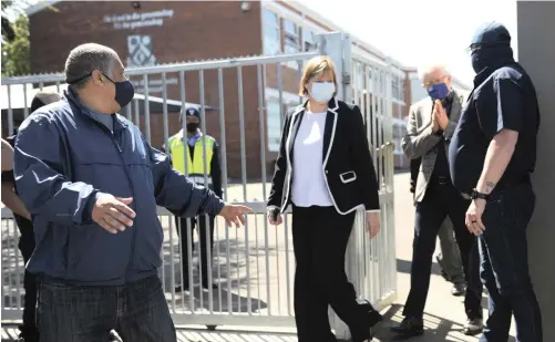  ?? | AYANDA NDAMANE African News Agency (ANA) ?? EDUCATION MEC Debbie Schäfer (centre) and Premier Alan Winde (second from right) arrive at Brackenfel­l High School on Monday after a violent confrontat­ion between parents and EFF members.